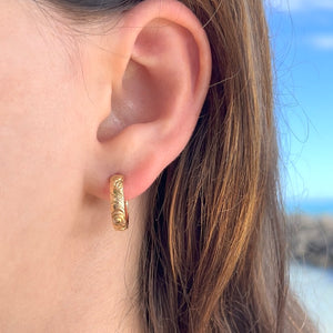 model wearing Old English & Hibiscus Round Hoop 4mm Earrings with Post in 14K Yellow Gold